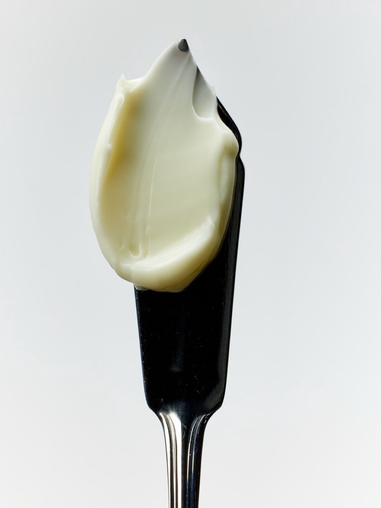 MelaBODY cream texture swatched on a black spatula