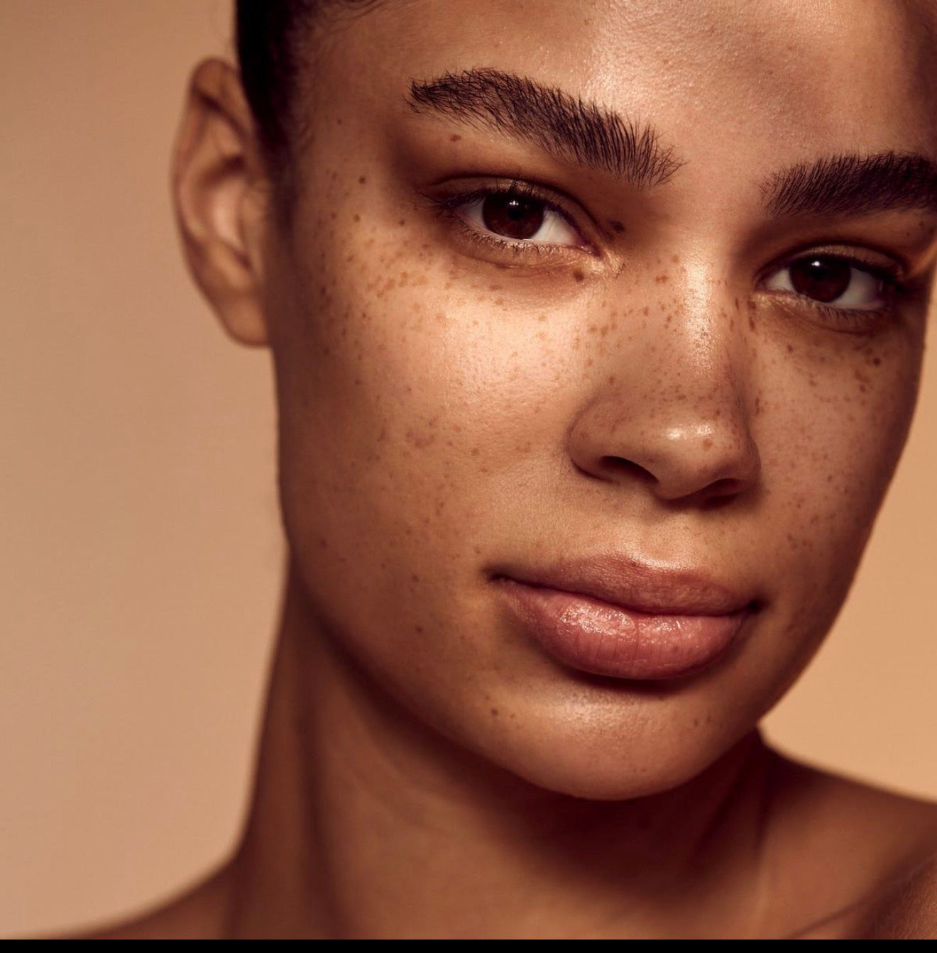Close portrait of a woman with freckles and a warm, natural glow